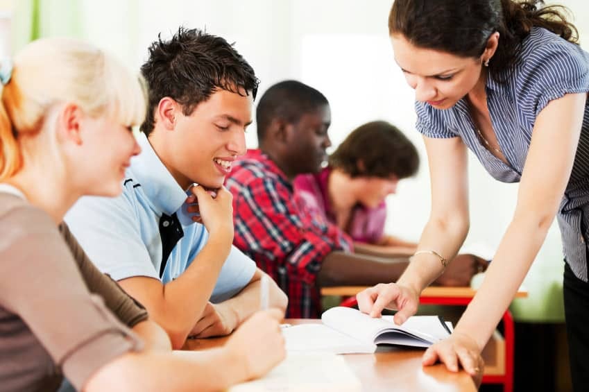 Young teacher helping students with their schoolwork