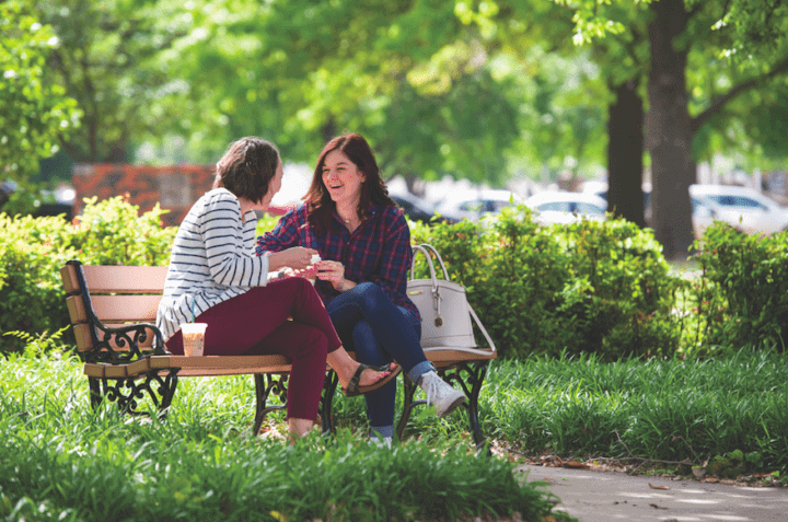 Oklahoma Baptist University friends catching up on a bench outside