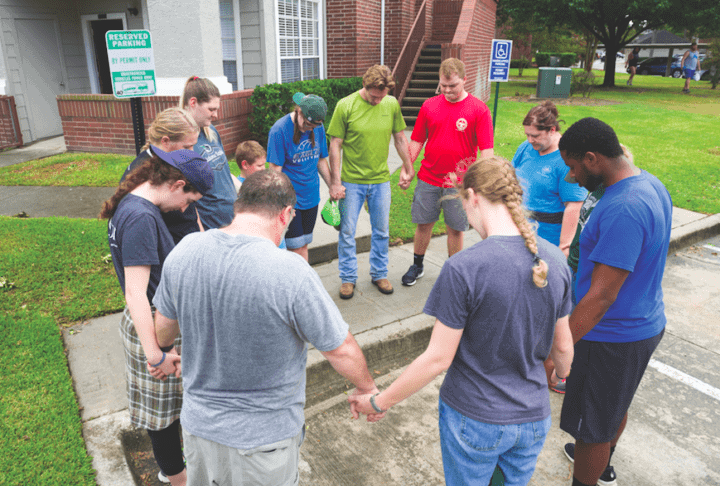 Oklahoma Baptist University students holding hands in prayer