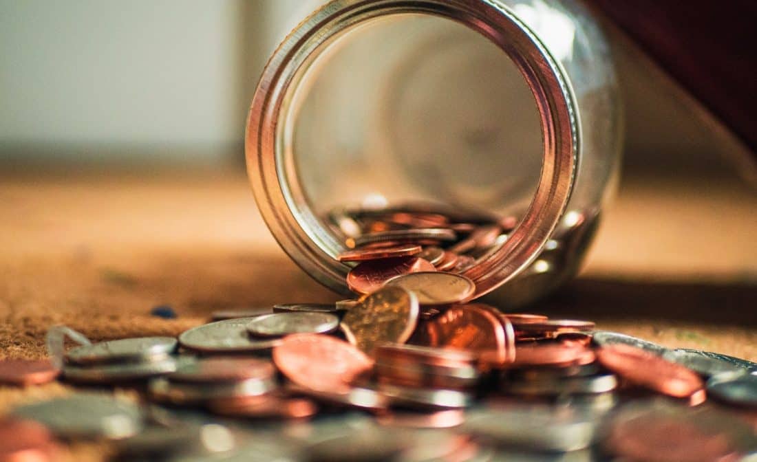 Jar tipped over with coins falling out