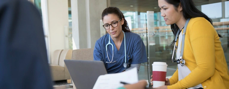 two female nurses looking at laptop
