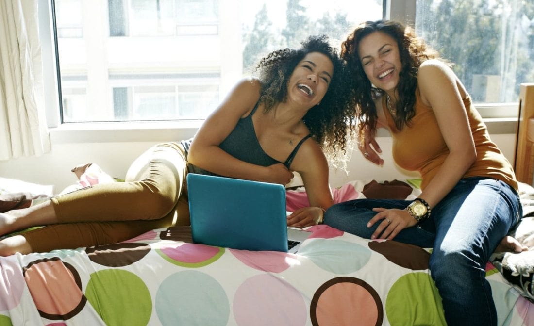 two female college students on dorm bed