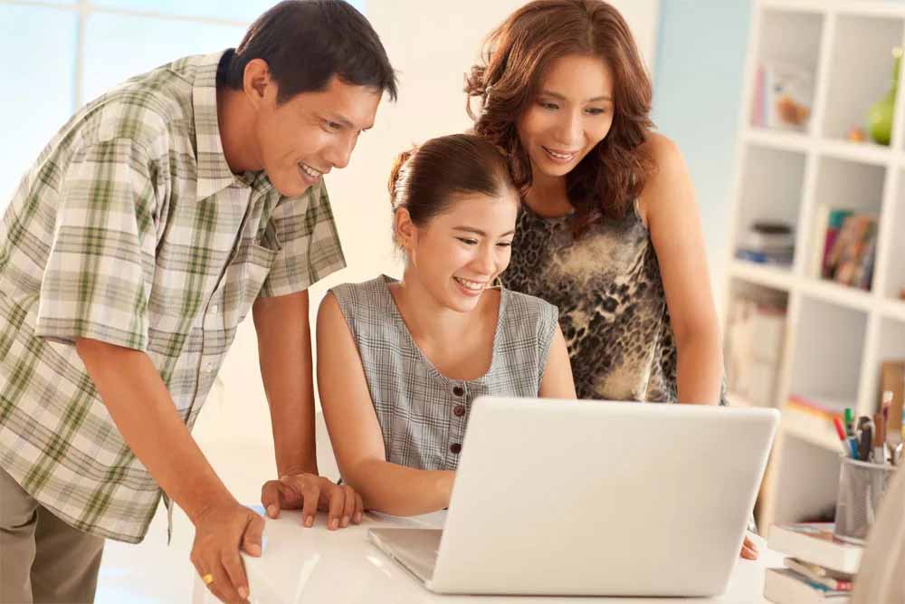 family looking at laptop